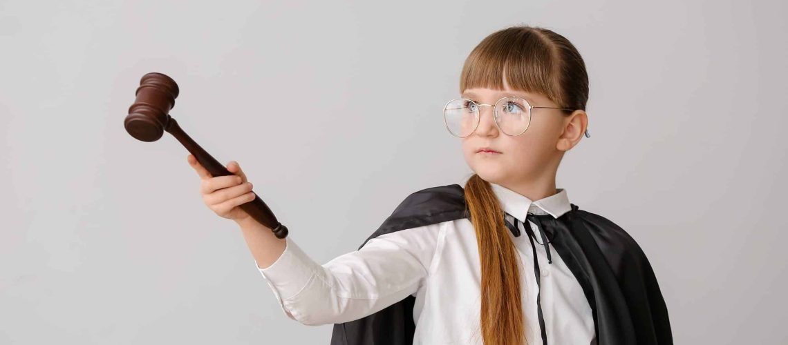 Portrait of little judge on grey background